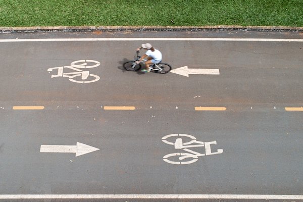 Mulher anda de bicicleta em ciclovia no Parque da Cidade