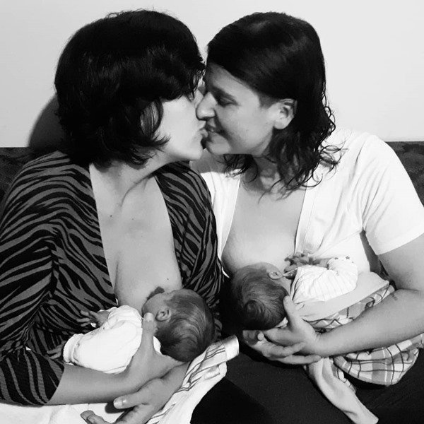 O casal homoafetivo amamentando os gêmeos