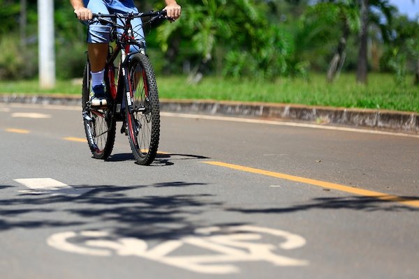 Ciclista pedala por ciclovia no Parque da Cidade