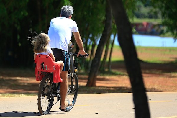 Pai e filha andam de bicicleta no Parque da Cidade