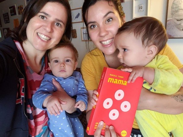 O casal e os filhos segurando o livro