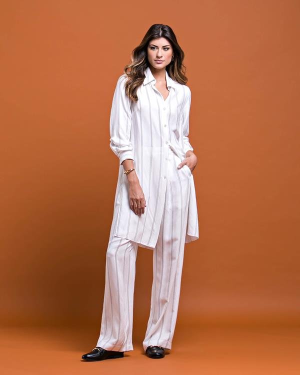 Mulher vestindo peças brancas da coleção Inverno 2020 da marca Cleo Aidar
