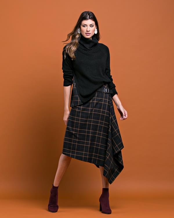 Mulher vestindo peças em preto e xadrez da coleção Inverno 2020 da marca Cleo Aidar