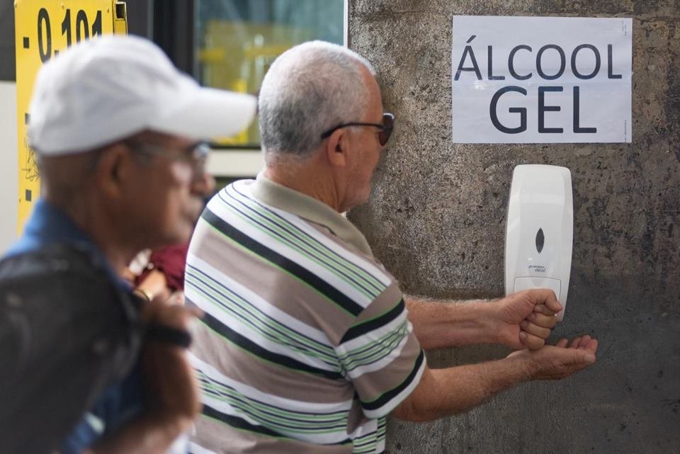 Pessoas usam álcool em gel contra o coronavírus na rodoviária do Plano Piloto