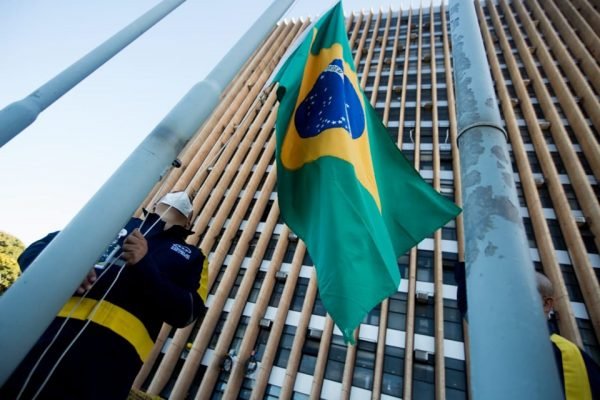 Servidor hasteia bandeira do Brasil em frente ao Anexo do Palácio do Buriti