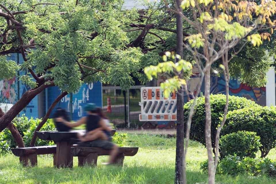 Pessoa sentada em banco no Taguaparque, em Taguatinga