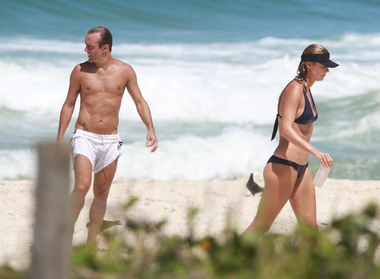 Roger Flores é visto na praia com a esposa