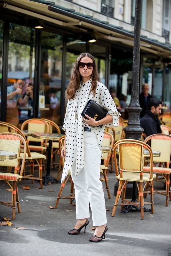mulher com blusa de bolinhas e calça branca em Paris