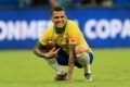 Dani Alves agachado com a camisa do Brasil