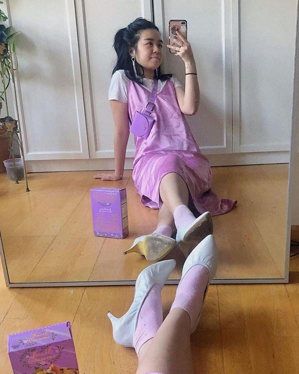 Mulher com vestido lilás e sapatos de salto para trabalhar de casa