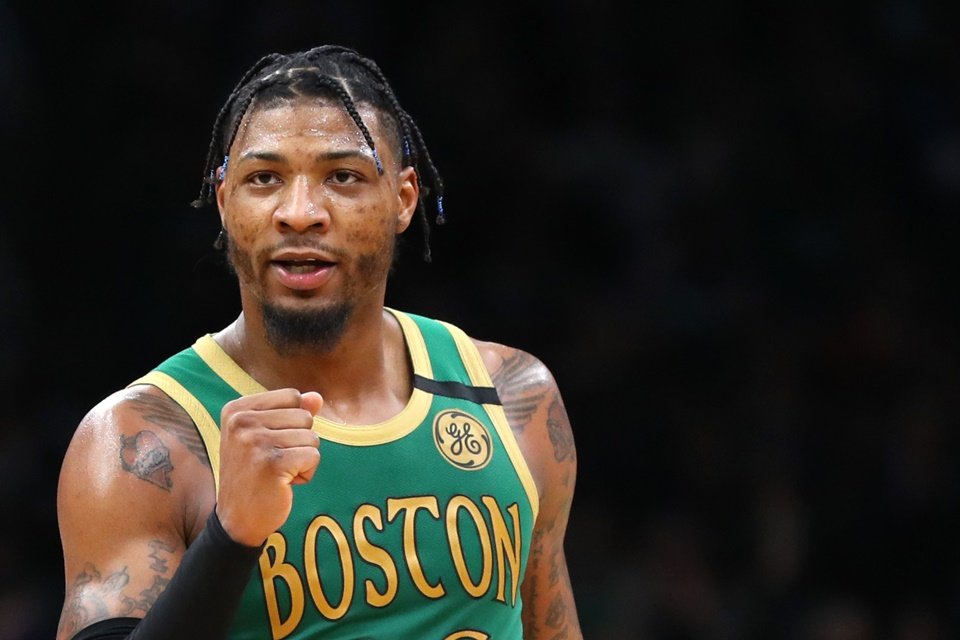 Marcus Smart com tranças e o punho fechado