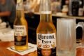 Cerveja Corona em cima de um balcão com uma caneca de chope do lado