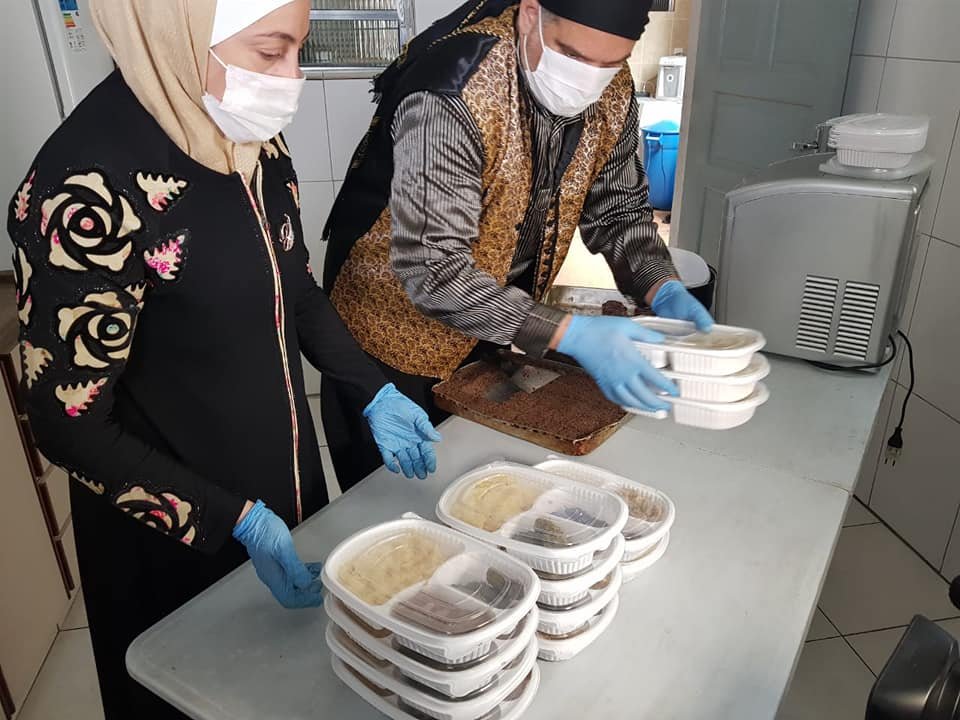 Refugiados sírios entregam marmitas para idosos durante pandemia do coronavírus