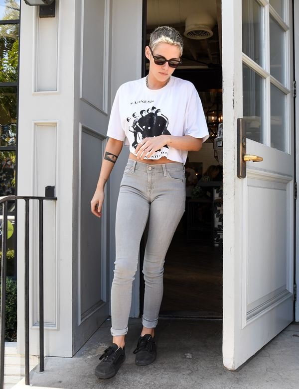 Kristen Stewart na rua com camiseta cropped e calça jeans