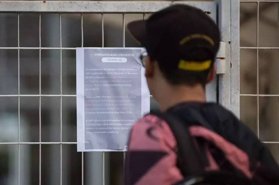 Aluno em frente de escola fechada