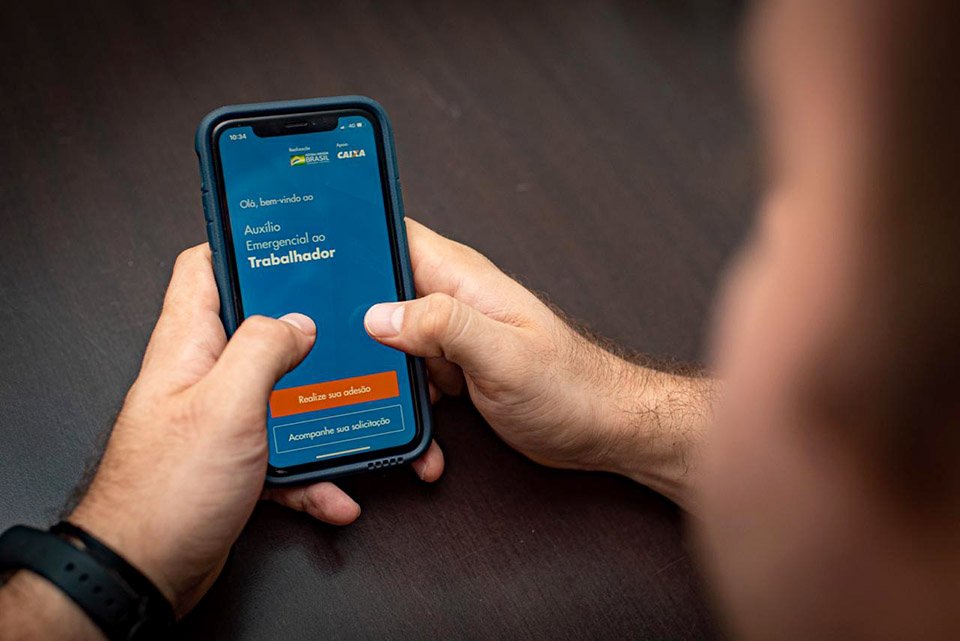Homem utiliza aplicativo app de auxilio do governo contra a falta empregos pelo covid19