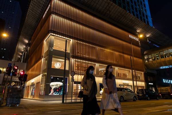 loja Hermès com pedestres de máscara