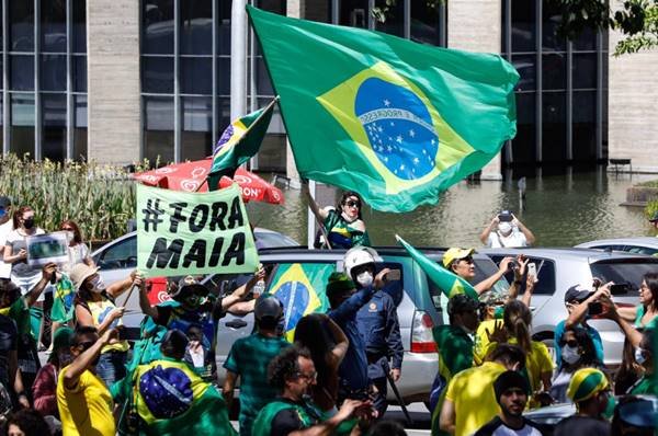 Manifestação com bandeira do Brasil com faixa escrita Fora Maia