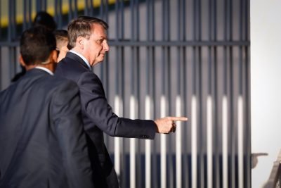 Bolsonaro aponta com o dedo e gesto é registrado em sombra na parede