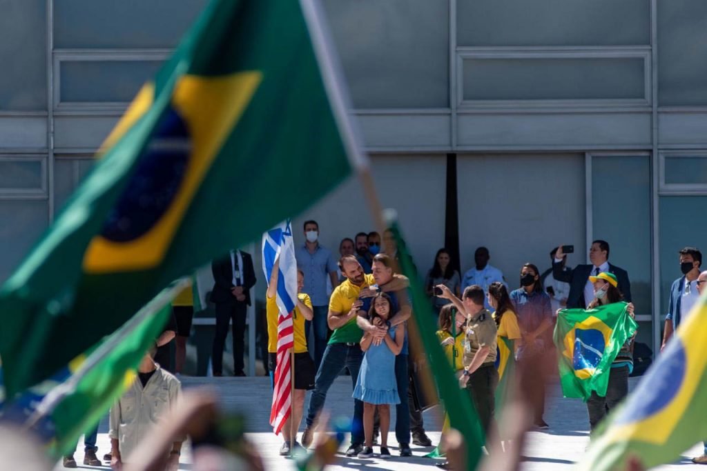 Eduardo Bolsonaro abraça o pai durante protesto em brasilia
