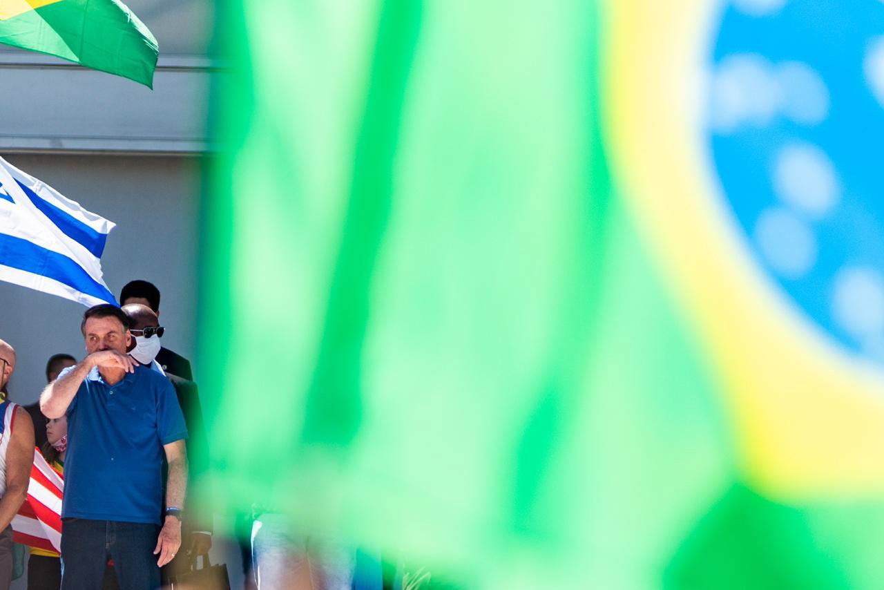 Bolsonaro coloca a mao no rosto durante protesto em brasilia