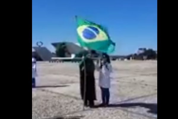 Mulher de boné e bandeira do Brasil na mão xingando enfermeira