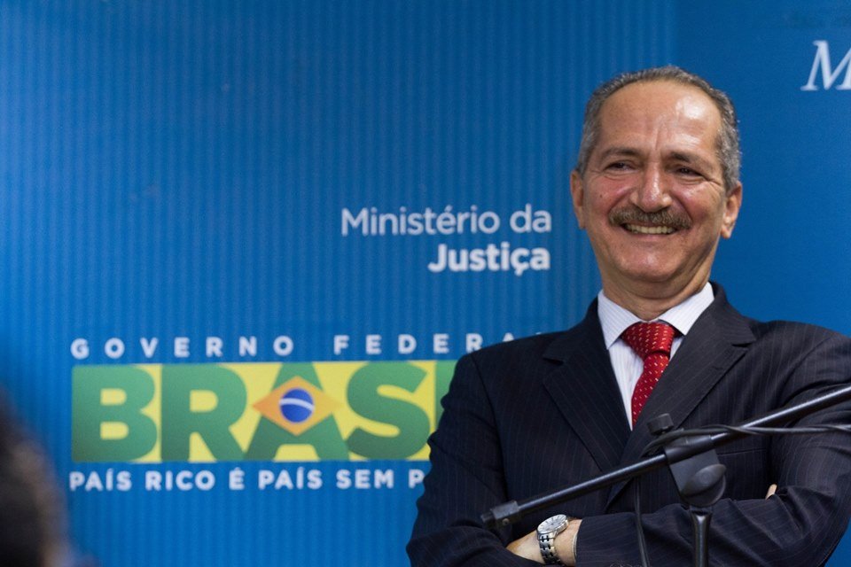 Aldo Rebelo sorrindo, de braços cruzados