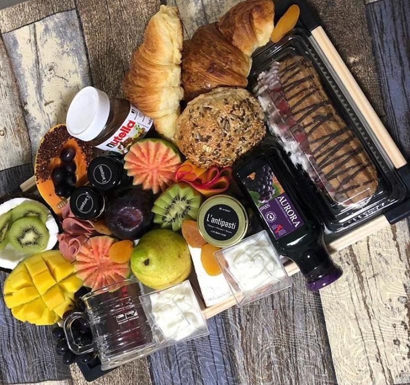 Cesta com frutas, doces, pães e suco