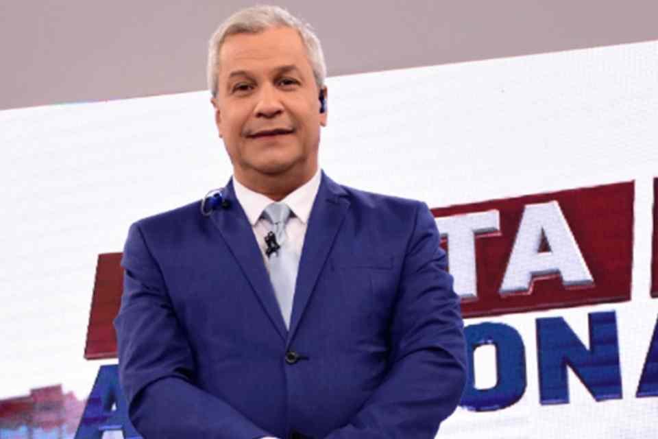 Foto do apresentador Sikêra Jr.. Ele está utilizando um terno azul, tem cabelo branco e é branco. Ele sorri para a câmera - Metrópoles