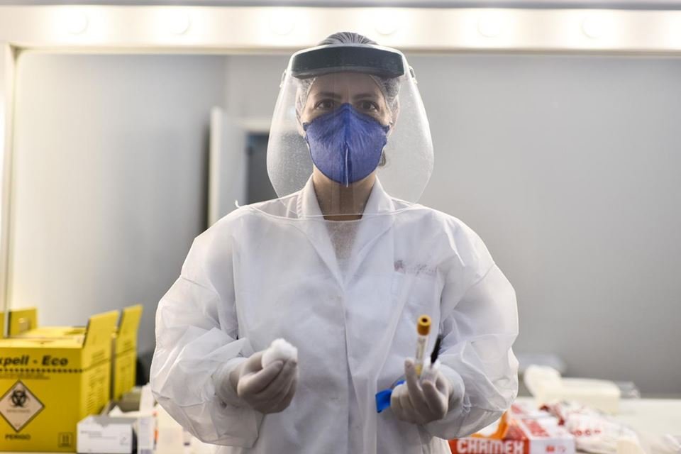 Profissional de saúde segurando testes coronavírus