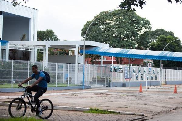 Ciclista pedala em frente a colégio