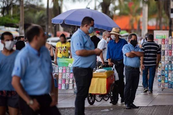 Pessoas na rua com máscaras