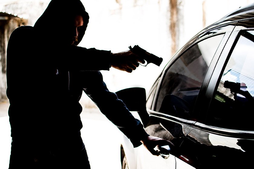 Homem aponta arma para carro