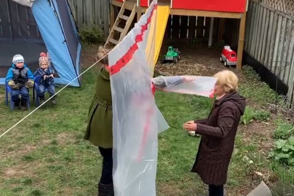 Duas mulheres se abraçando através de um plástico