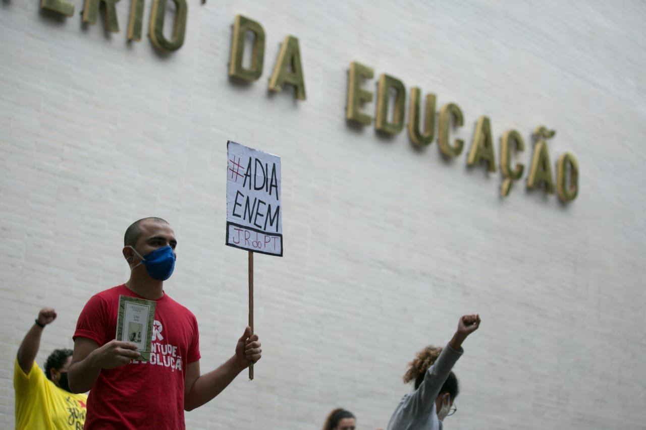 pessoas segurando placas e com a mão para cima