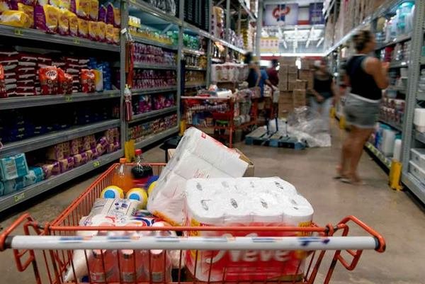 carrinho de compras cheio e prateleiras supermercado