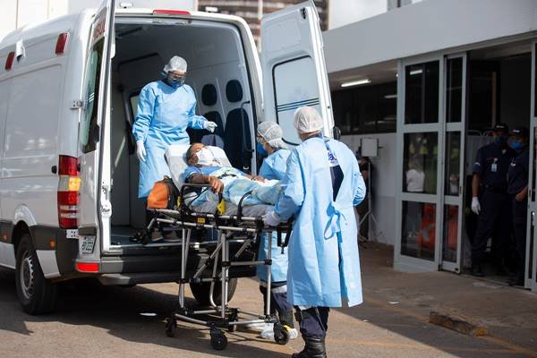 Servidores transportam paciente em maca