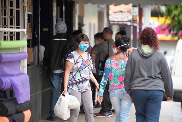 Mulher de máscara com compras
