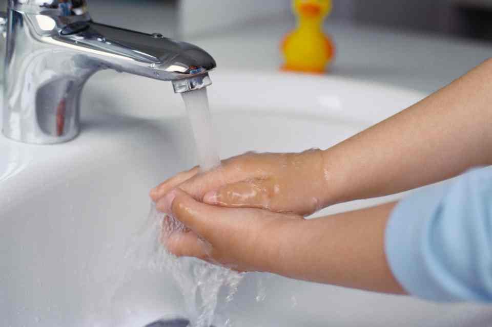 Criança lavando a mão