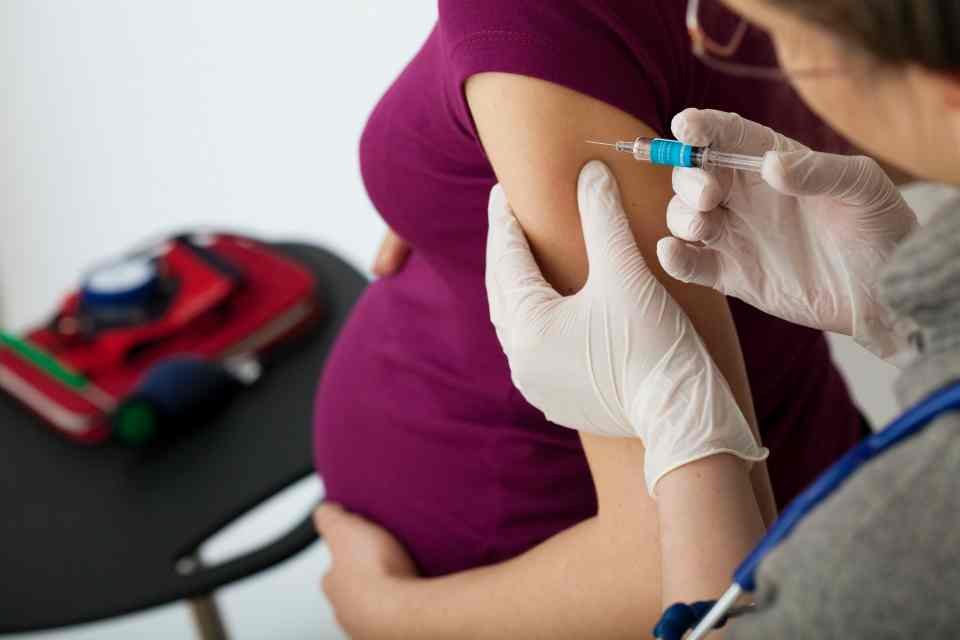 Grávida tomando vacina