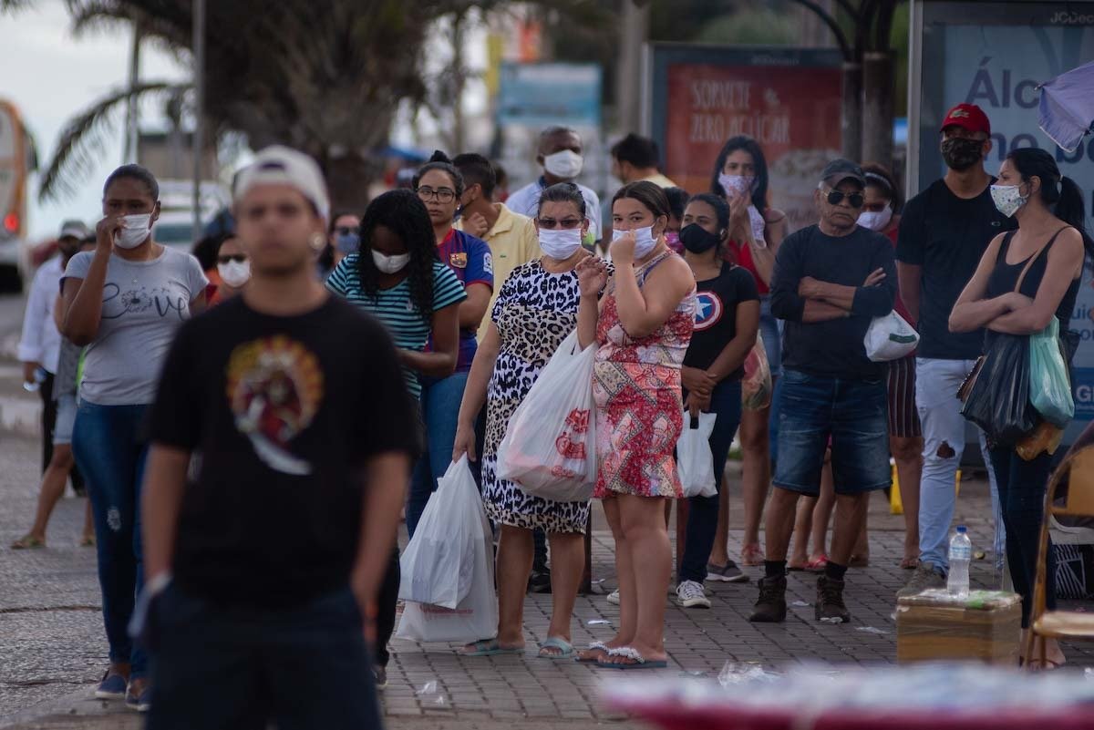 moradores do df usam máscaras e aguardam ônibus em parada