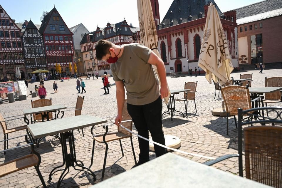 Dono de restaurante mede distância entre cadeiras em Frankfurt, na Alemanha