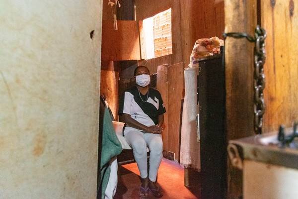 Mulher com máscara em casa
