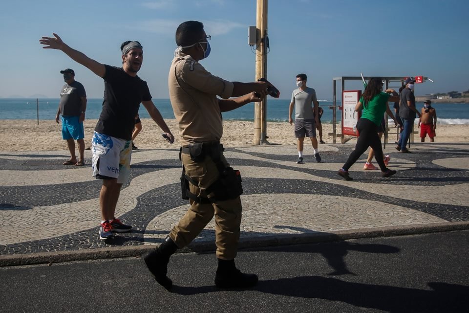 Policial militar com a arma empunhada em protesto em Copacabana