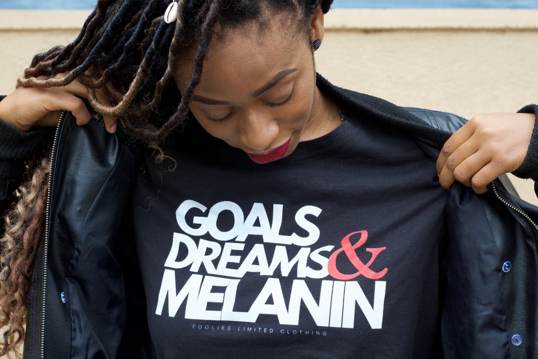 mulher negra com camiseta com mensgem antirracista