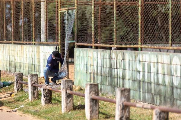 Fiscal fechando acesso de quadra esportiva