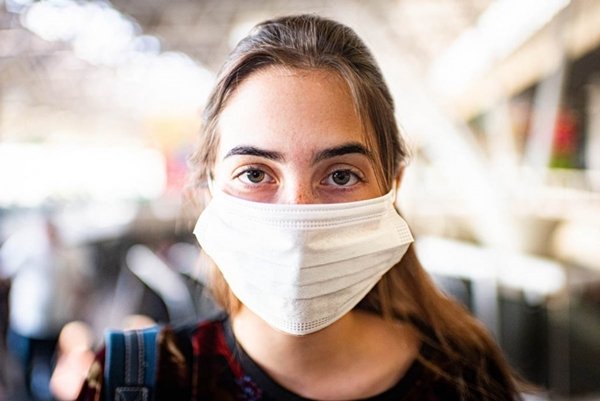 Jovem mulher usando máscara de proteção