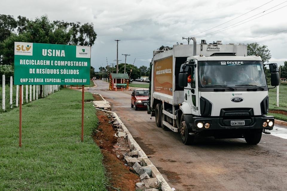 Caminhão de lixo saindo de usina de compostagem