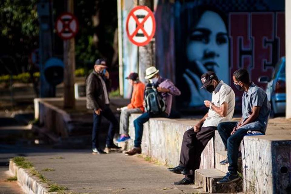 Pessoas sentadas na rua de Ceilândia