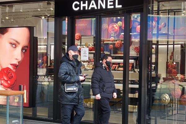 Homens passando na frente de loja da Chanel em Pequim, na China
